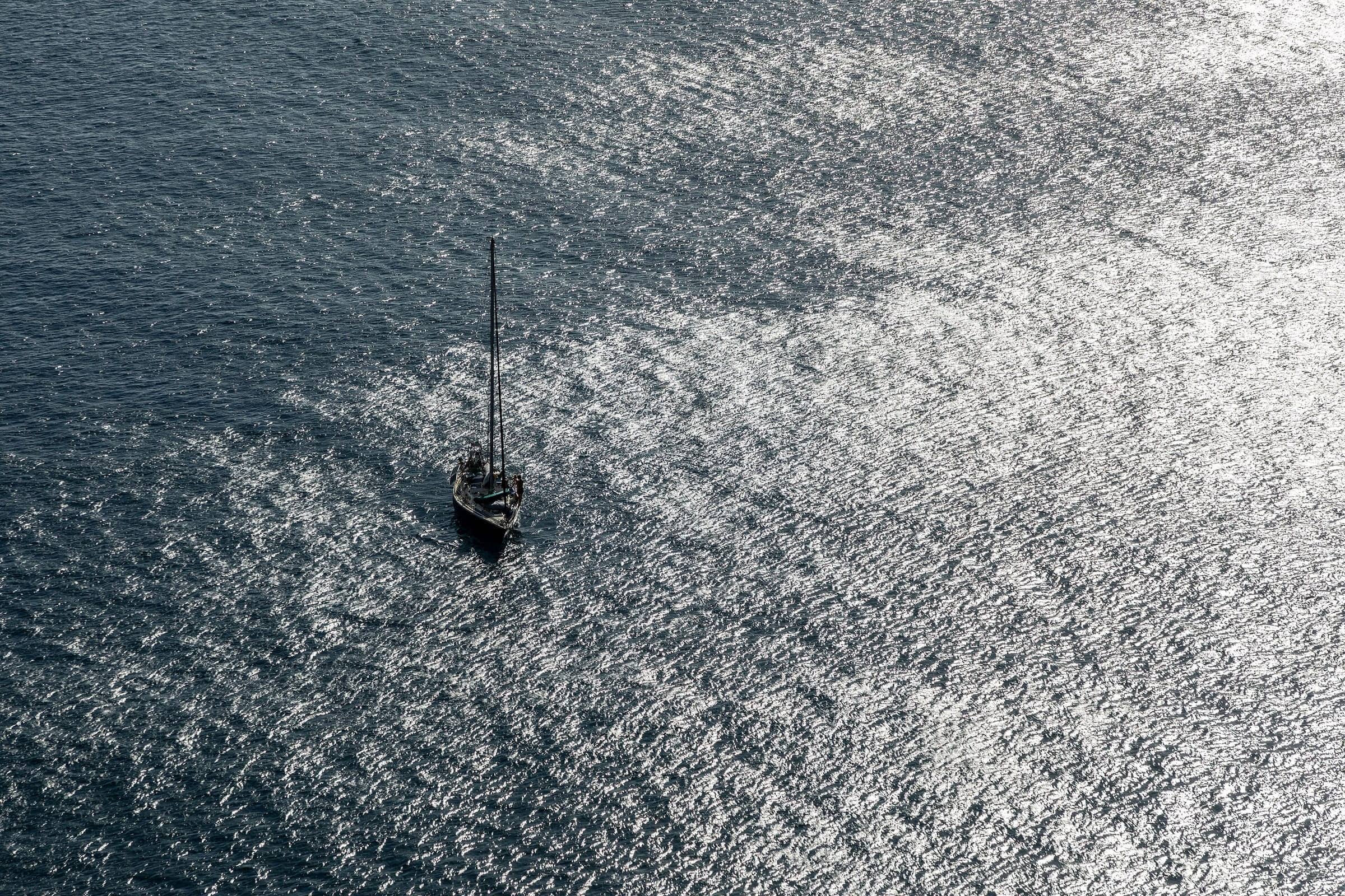 Un voilier seul sur l’océan scintillant, vu d’en haut